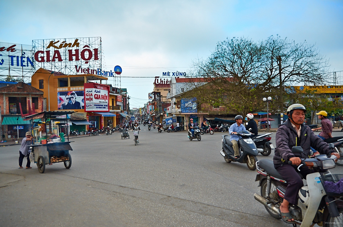 Typical Vietnamese street scene with scooters and food carts